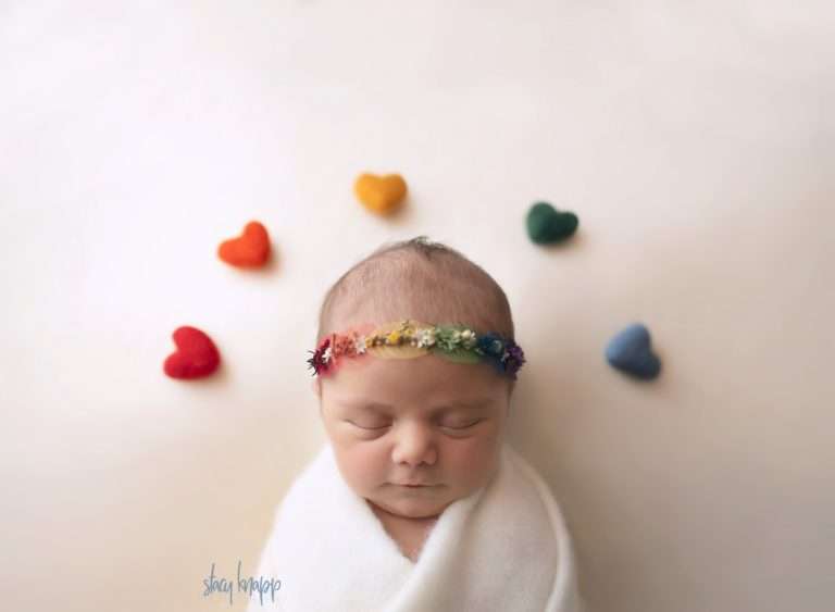 Maine newborn baby girl with rainbow of hearts above by photographer Stacy Knapp Photography