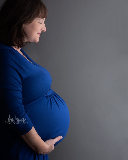 Maine maternity portrait pregnant mother with baby boy in blue dress by photographer Stacy Knapp Photography