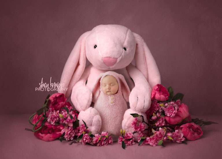 Newborn photograph of a baby girl in a soft pink bunny outfit