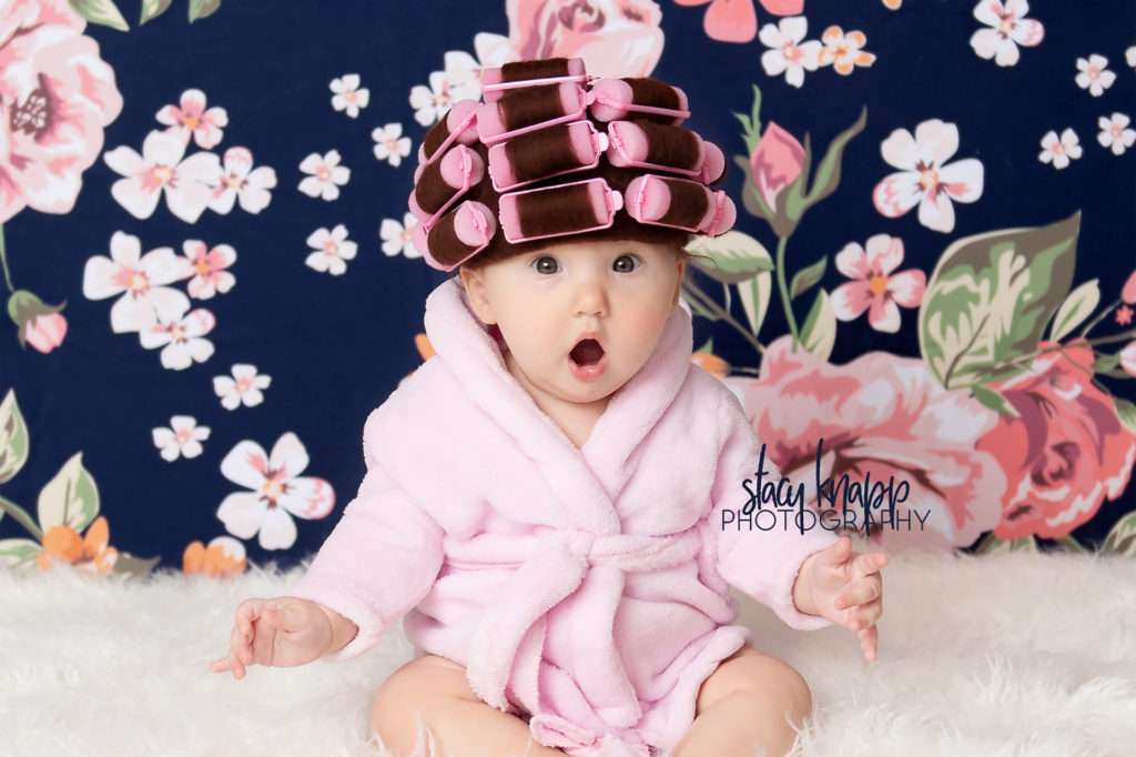 Baby girl photographed in hair curlers and a bathrobe