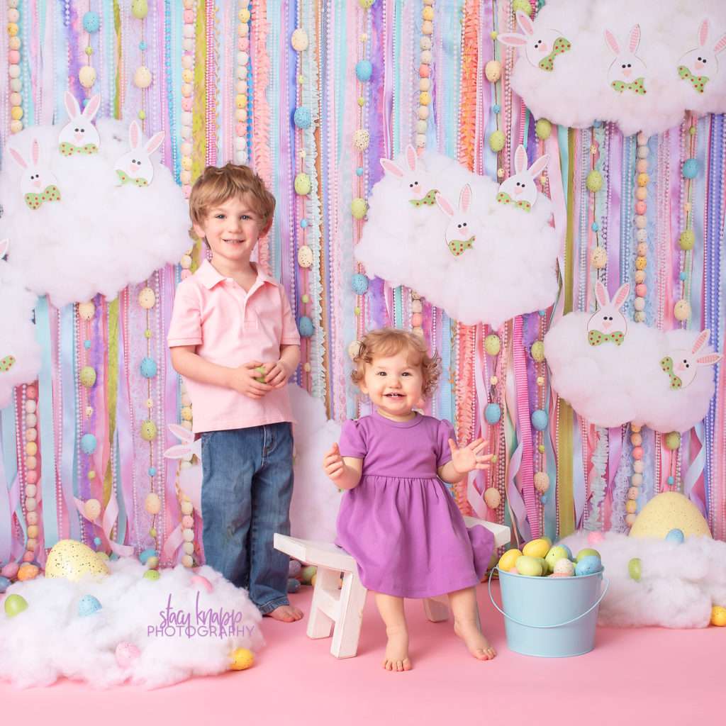 Baby girl and preschool boy Easter photograph on an Easter egg backdrop during a mini session