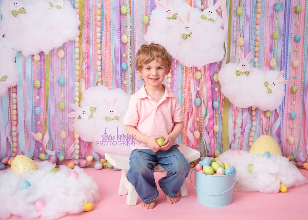 Preschool boy Easter photograph on an Easter egg backdrop during a mini session