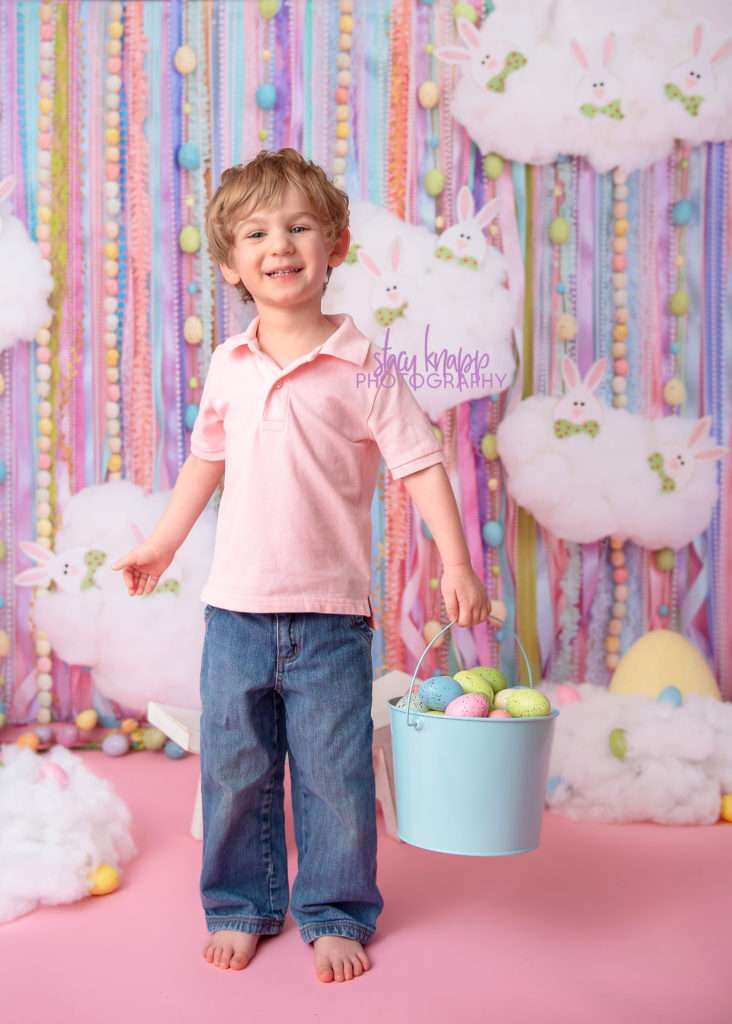 Preschool boy Easter photograph on an Easter egg backdrop during a mini session