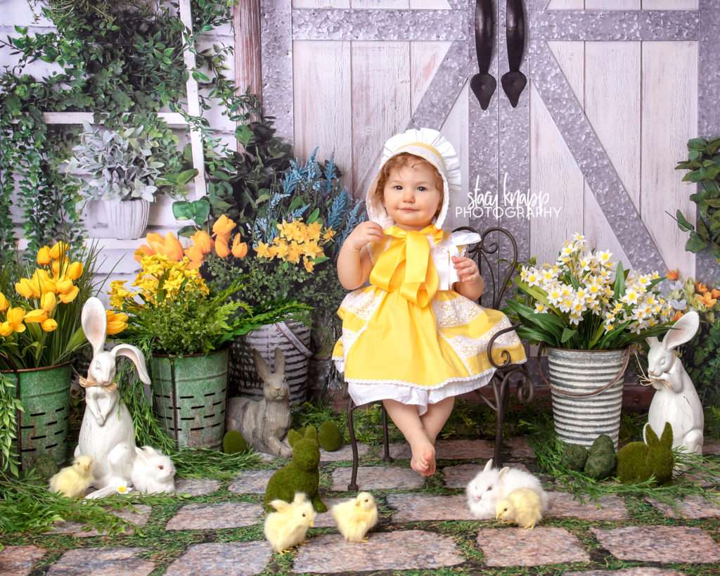 Spring mini session photograph of a baby girl in adorable yellow dress and matching bonnet