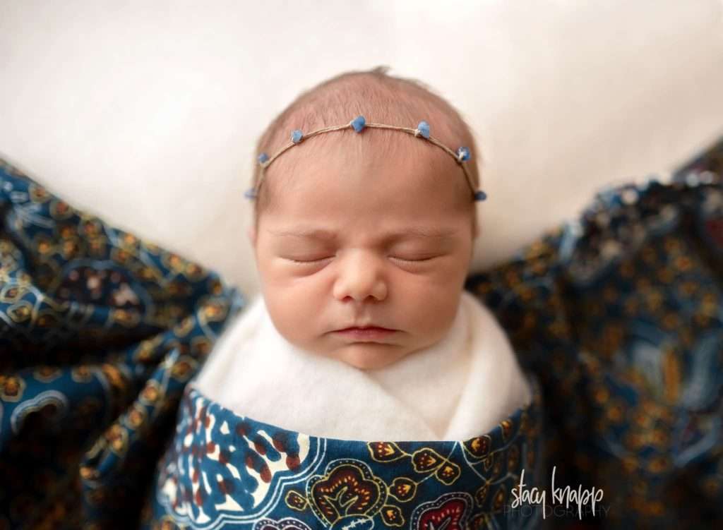 Maine newborn baby girl covered in African fabric from the Peace Corps by photographer Stacy Knapp Photography