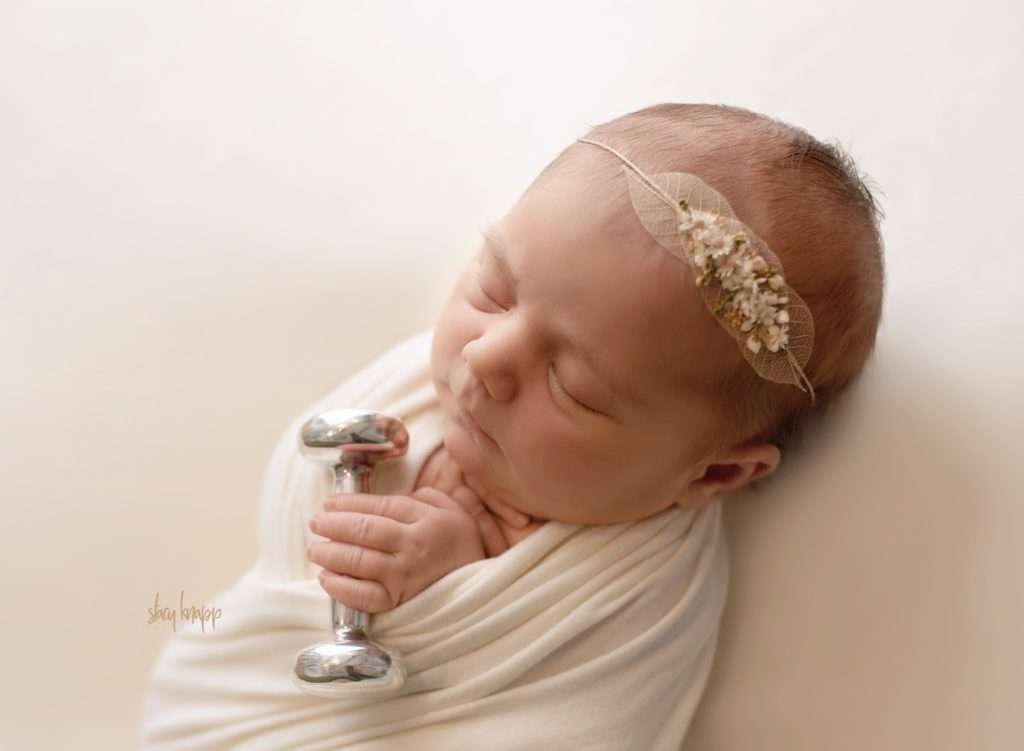 Maine newborn baby girl holding heirloom baby rattle by photographer Stacy Knapp Photography