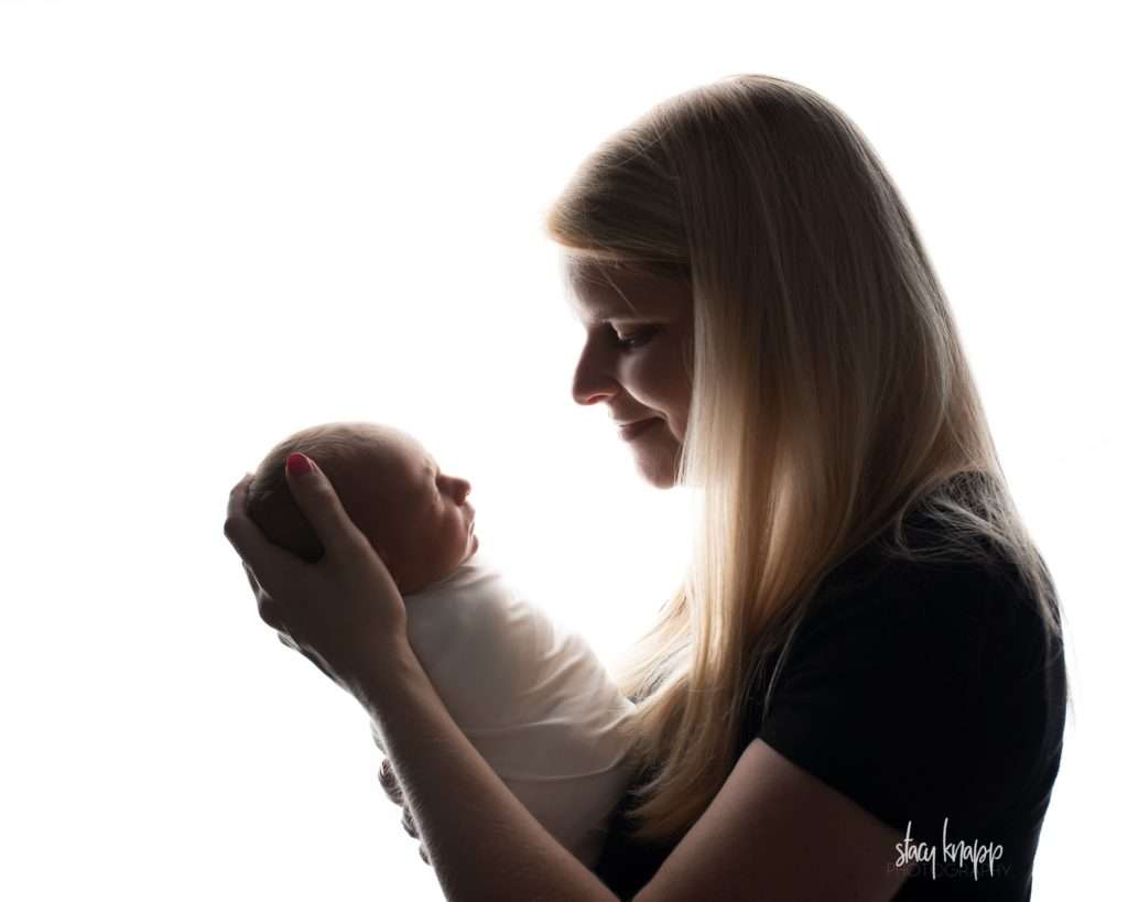 Backlit mom with newborn baby boy