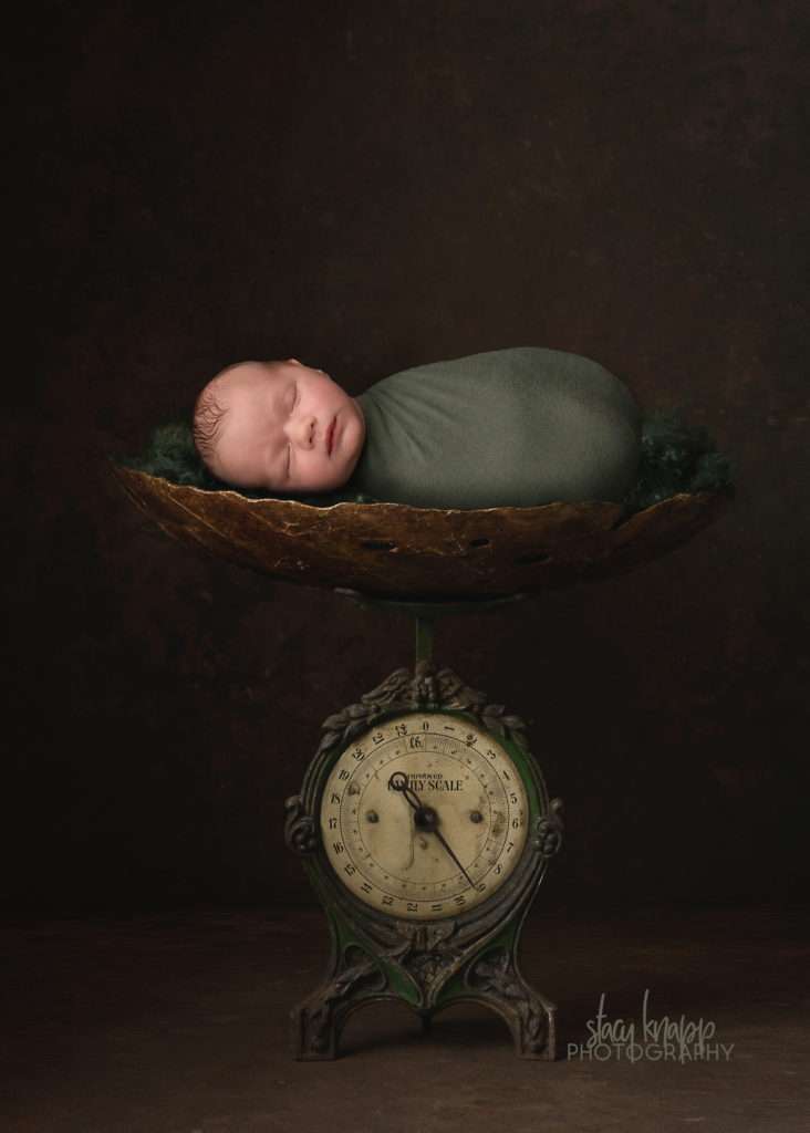 newborn baby boy photo wrapped in green on scale