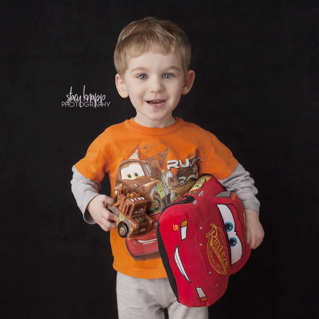 Toddler photographed with cars characters