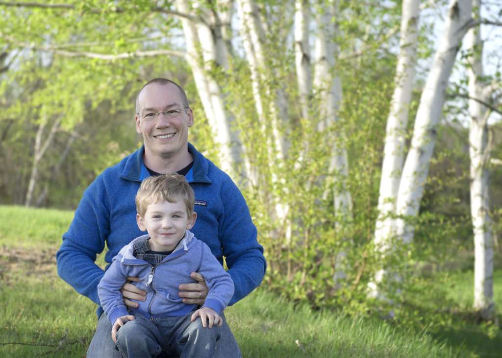 Photograph of a father and son playing near some birch trees in Augusta, Maine