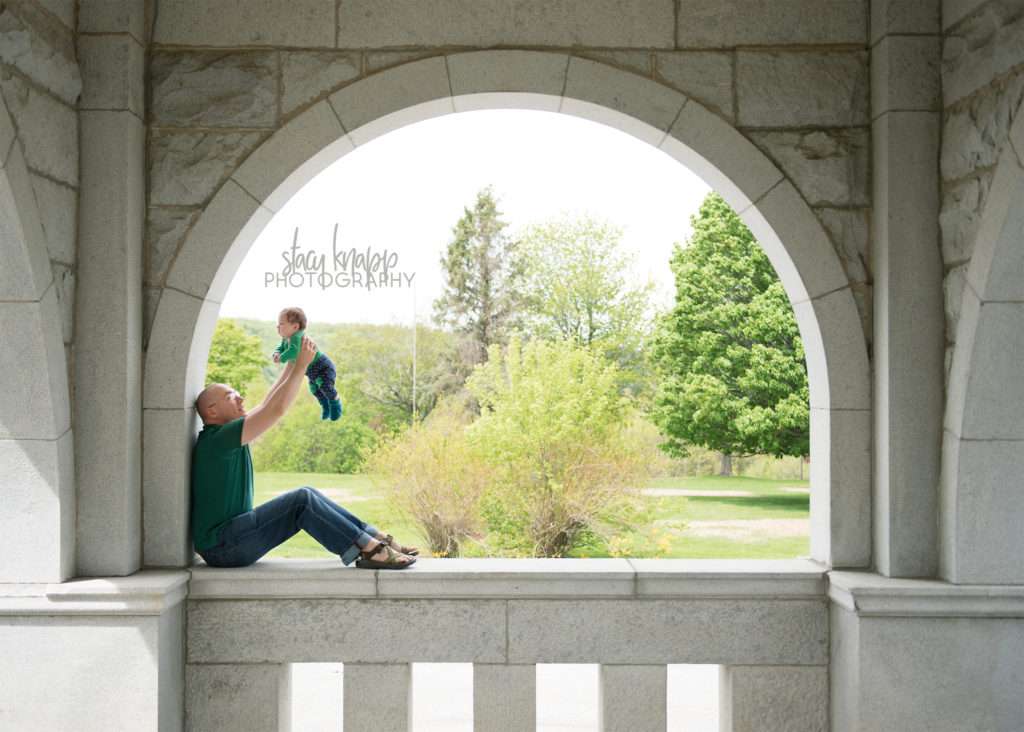 Father and daughter photographed on a stone wall in Augusta, Maine