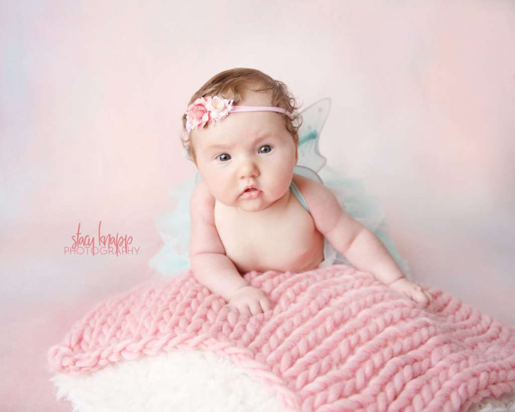 Four-month-old baby girl photographed wearing pink and turquoise wings