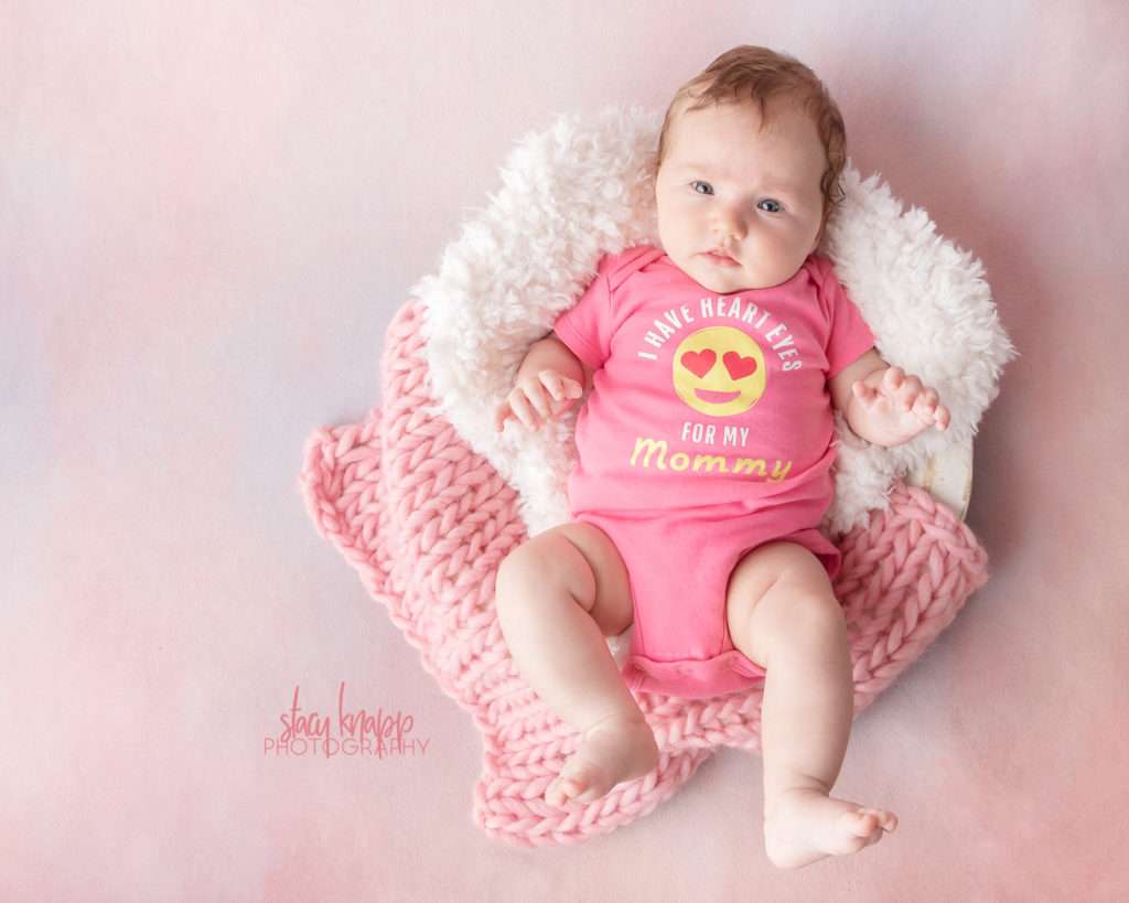 Four-month-old baby girl photographed wearing heart eyes for mommy onesie