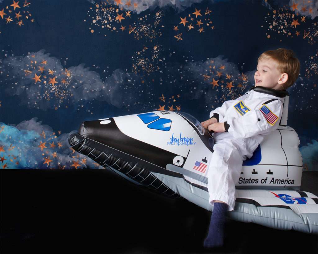 Toddler boy photographed riding space ship