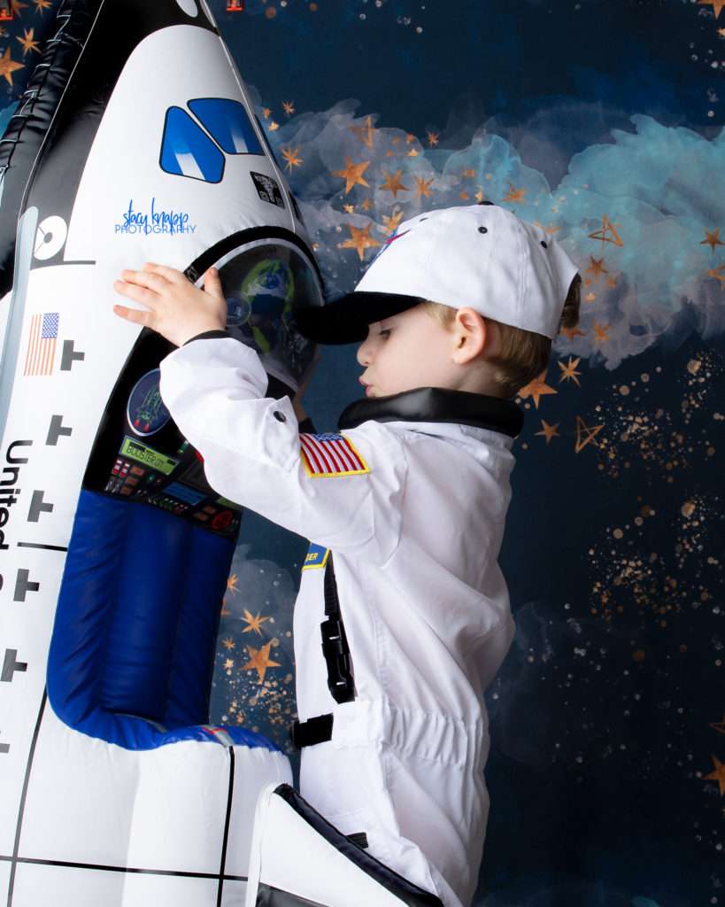 Toddler boy photographed looking at space ship