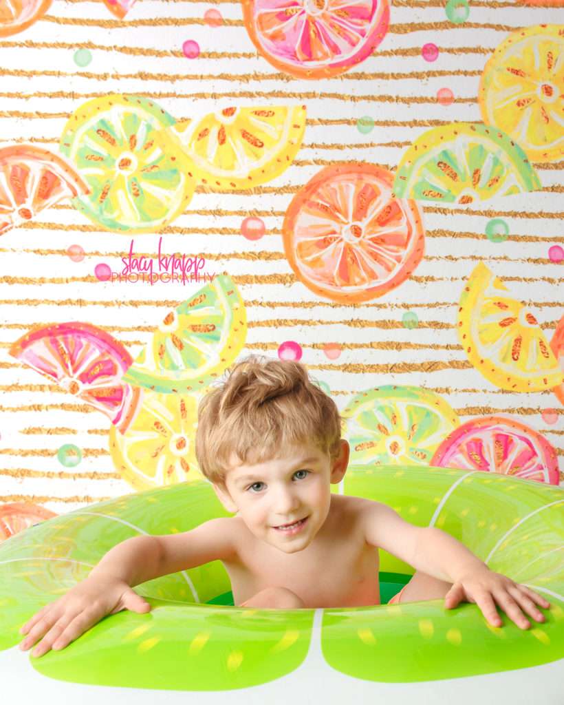 Toddler boy photographed in lime float with citrus backdrop