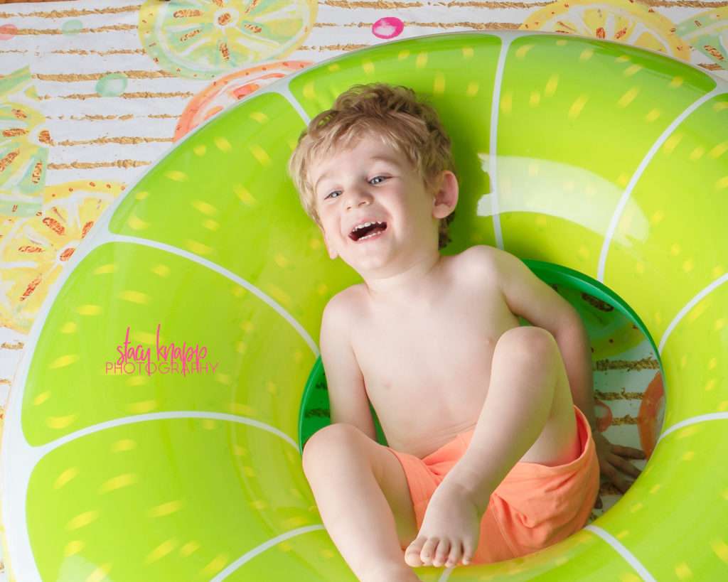 Toddler boy photographed in lime float with citrus backdrop