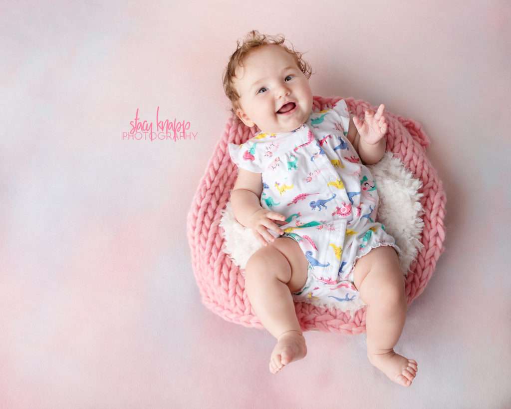 Five-month-old baby girl photographed on pink backdrop