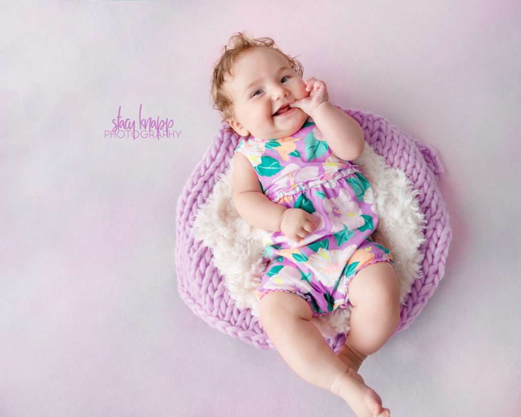 Five-month-old baby girl photographed on pink backdrop