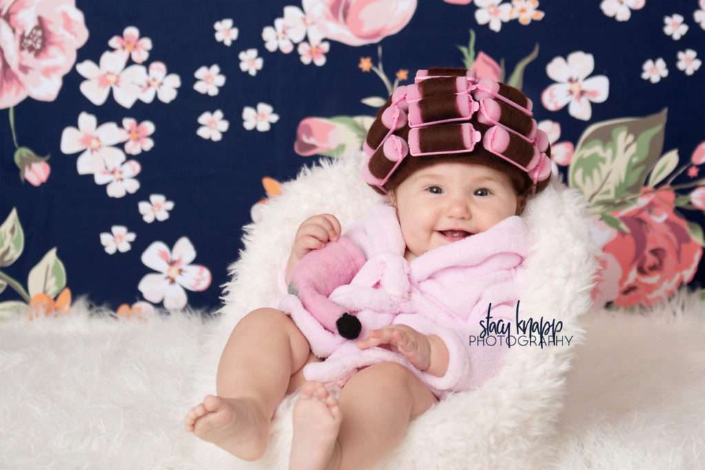Baby girl photographed in hair curlers and a bathrobe
