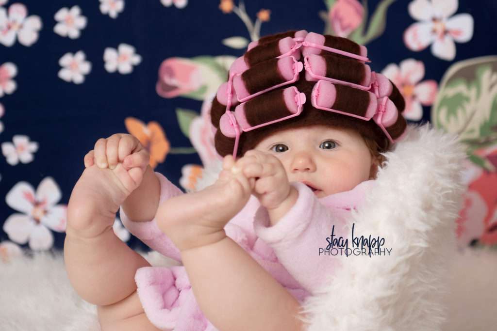 Baby girl photographed in hair curlers and a bathrobe