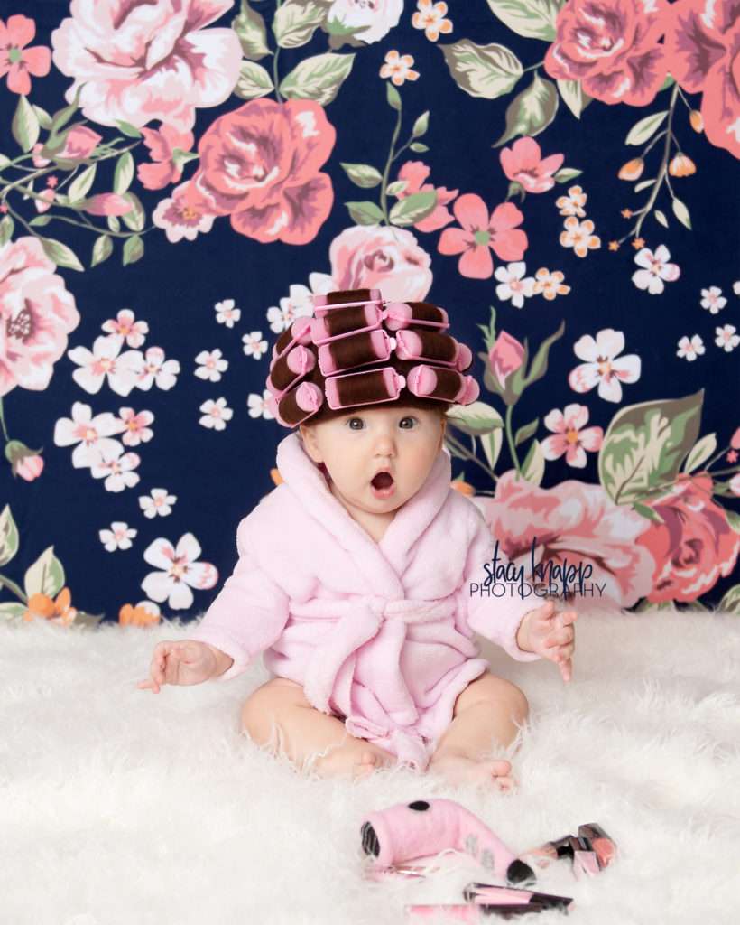 Baby girl photographed in hair curlers and a bathrobe