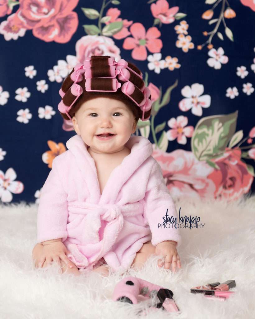 Baby girl photographed in hair curlers and a bathrobe
