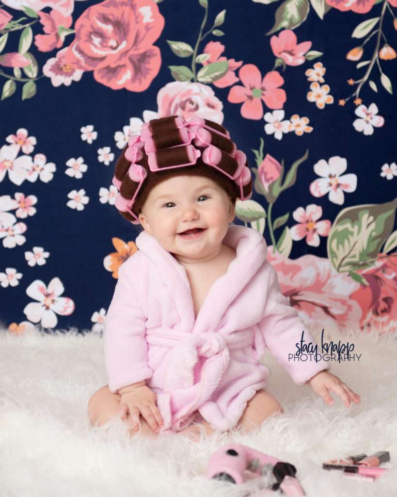 Baby girl photographed in hair curlers and a bathrobe