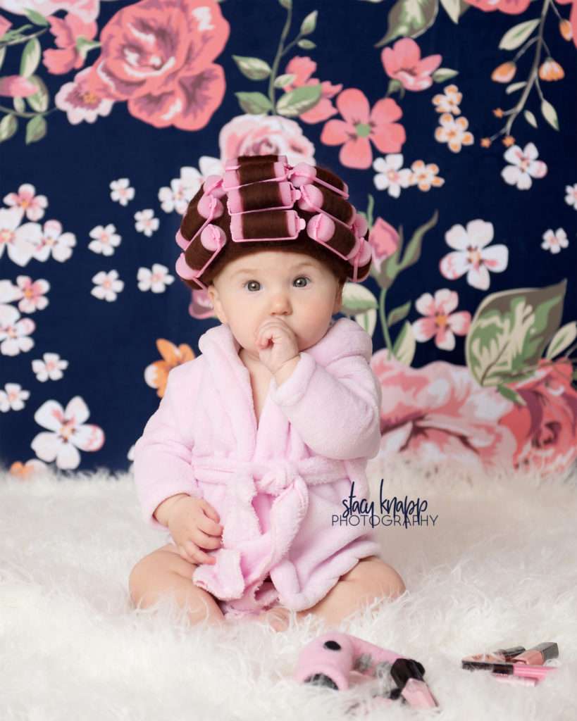 Baby girl photographed in hair curlers and a bathrobe