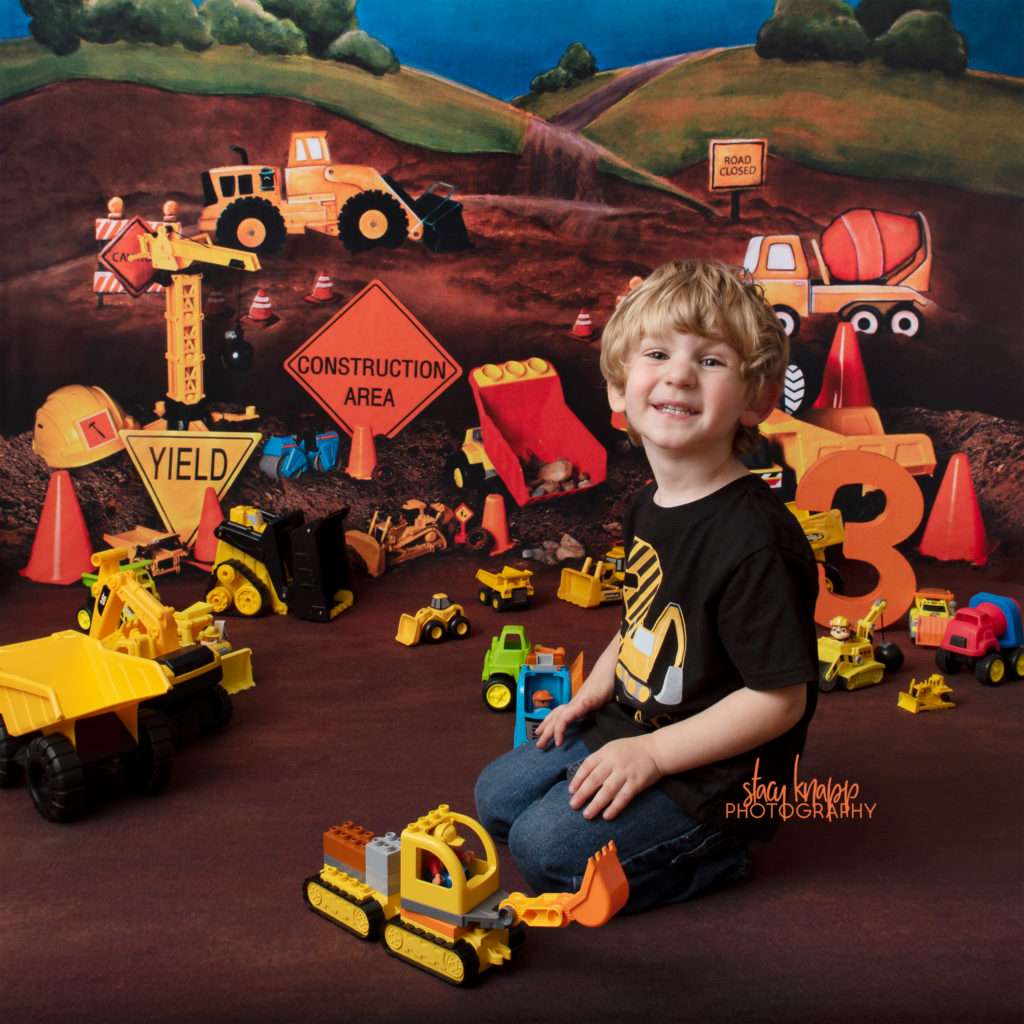 Preschool boy age three photographed on truck backdrop