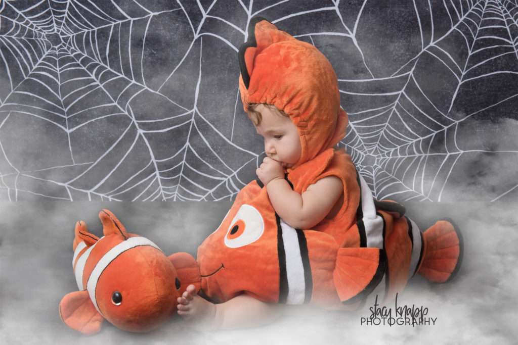 Baby girl photographed on Halloween backdrop wearing finding Nemo costume