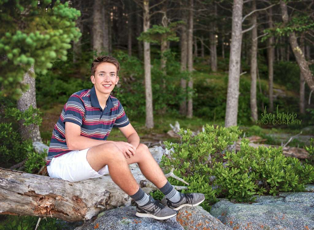 High school senior boy sitting on rocks