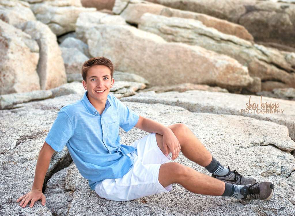 High school senior boy sitting on rocks
