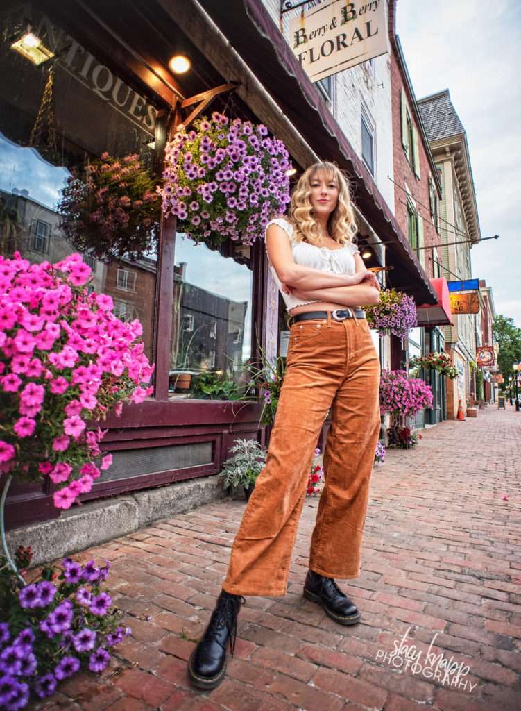 Senior girl standing in front of flowers