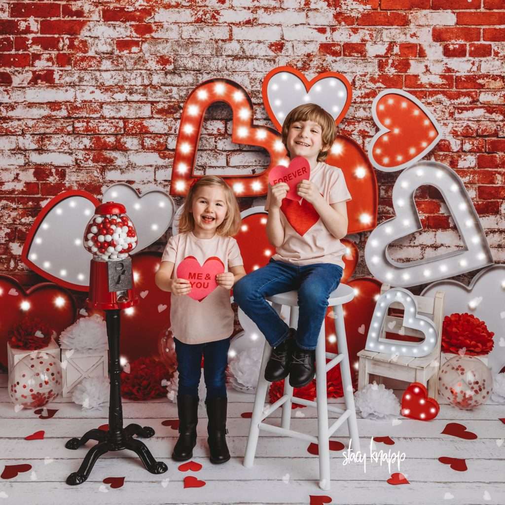 Brother and sister celebrating valentines day at Stacy Knapp Photography sister standing and brother sitting holding hearts