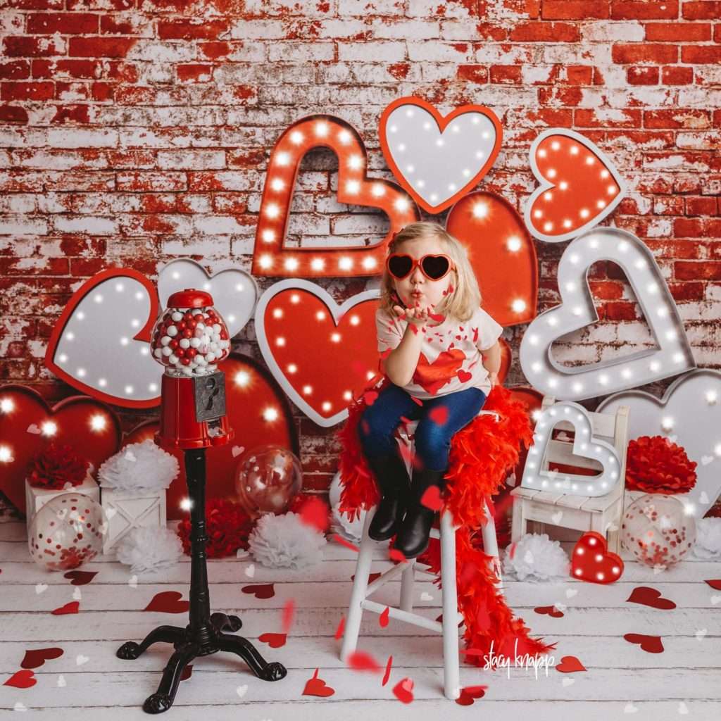 Young girl celebrating valentines day at Stacy Knapp Photography blowing kisses