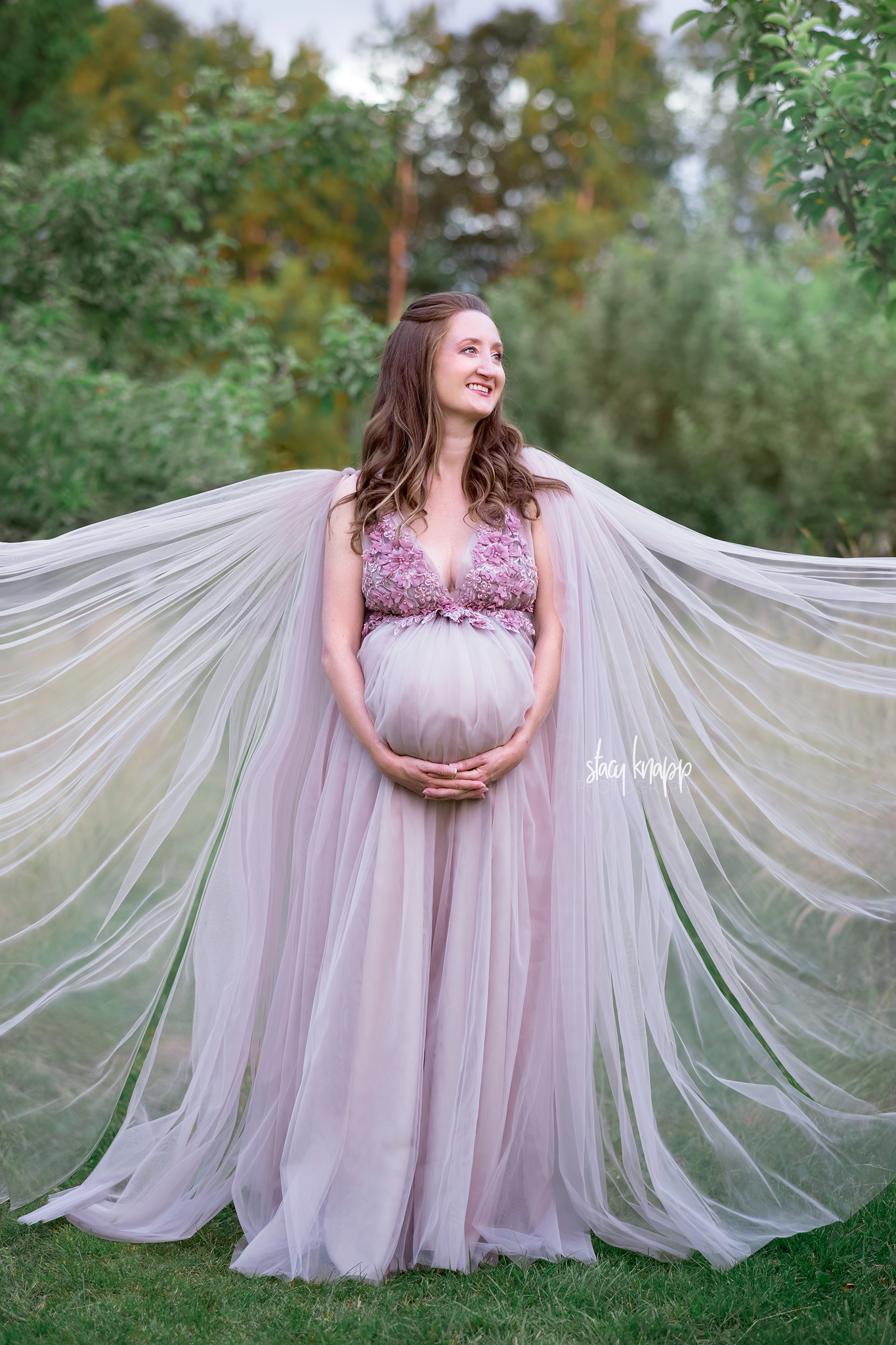 Maternity photo of a pregnant Maine mother in a pink floral gown at the Viles Arboretum in Augusta by photographer Stacy Knapp Photography