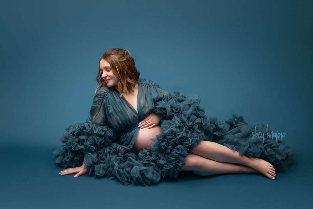 Photo of a pregnant Maine mother wearing a teal luxury maternity gown by photographer Stacy Knapp Photography