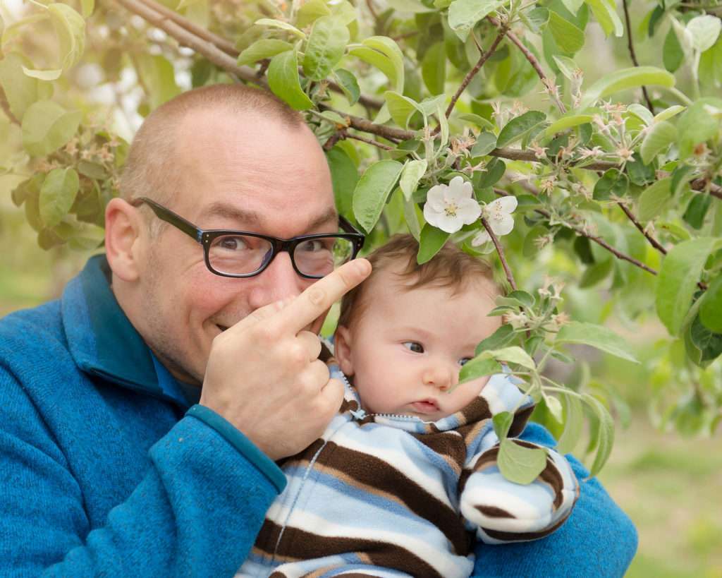 Daddy and baby girl in an apple orchard in the spring
