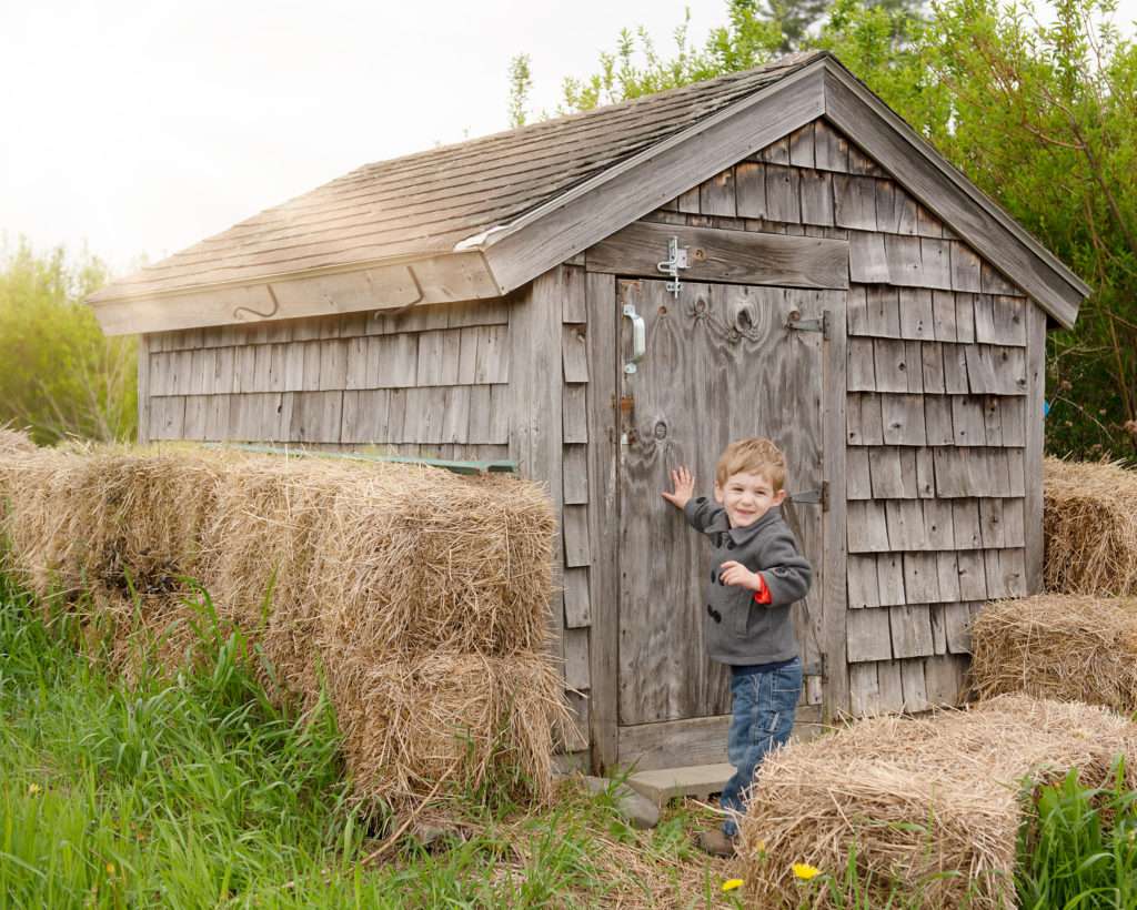 Preschool boy near an old shed  during a mini session