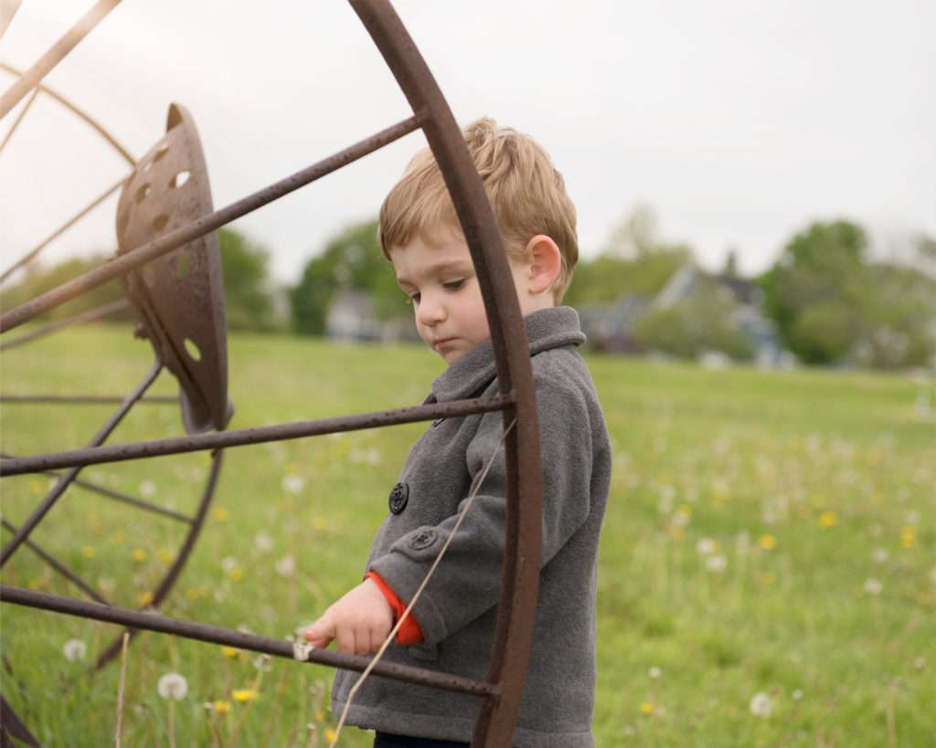Preschool boy near an old piece of farm equipment during a mini session