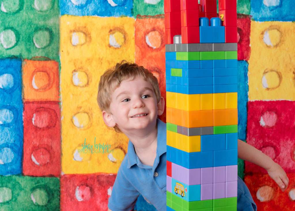 Preschool boy on lego backdrop
